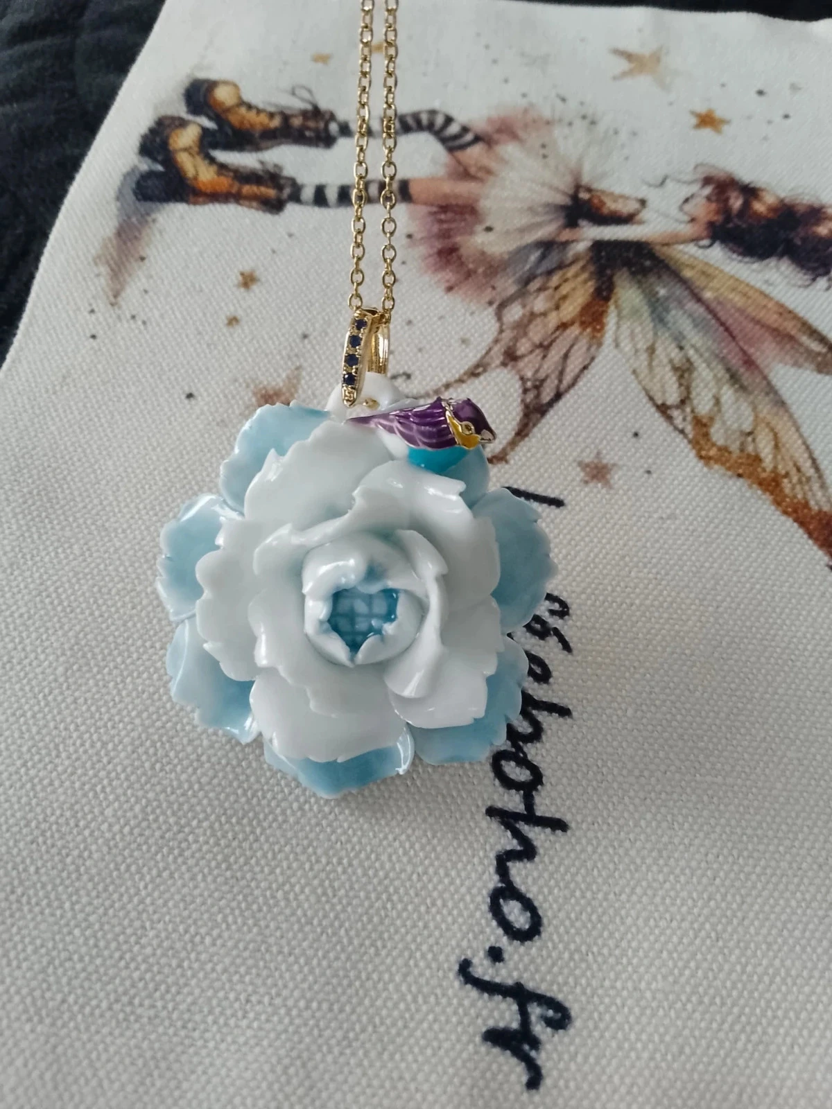 Collier fleur bleue et blanche en céramique avec oiseau coloré